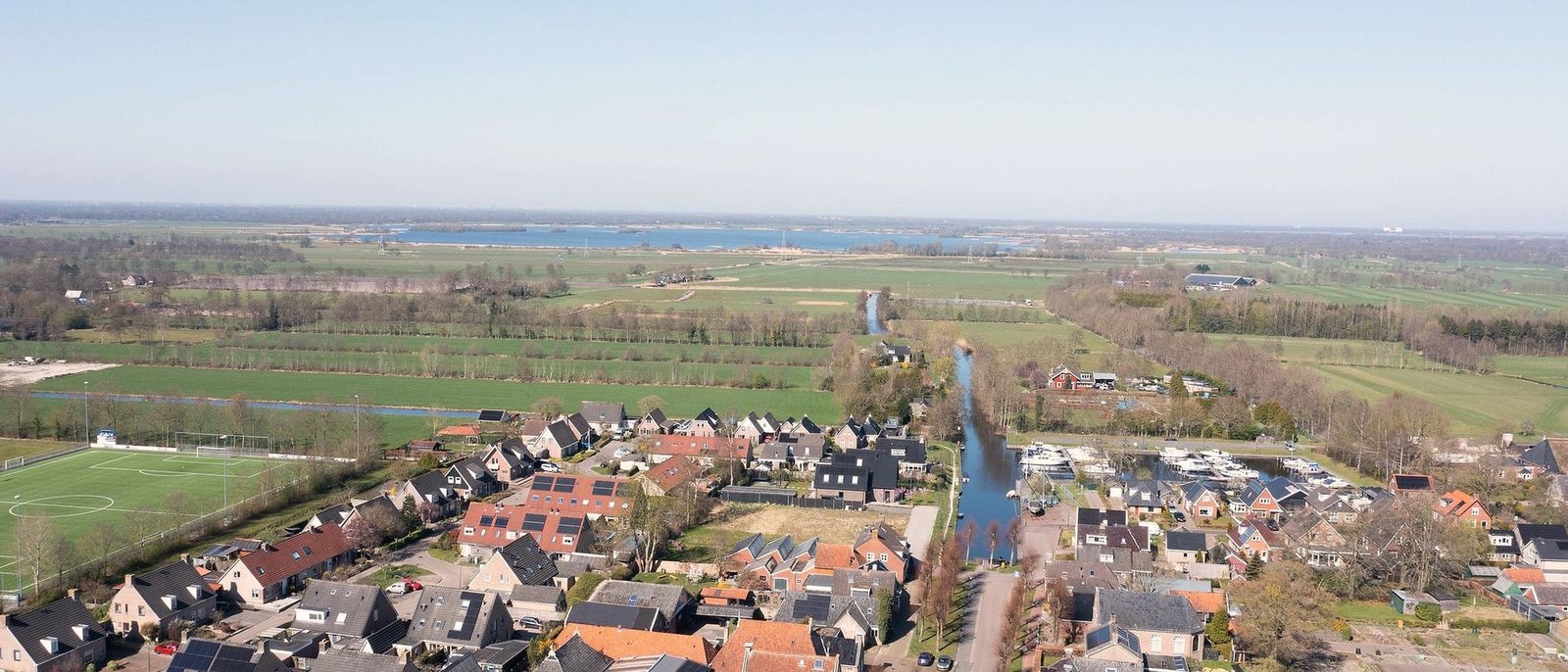 Luchtfoto van Rottevalle: de huizen van het dorp, met weilanden en water eromheen.